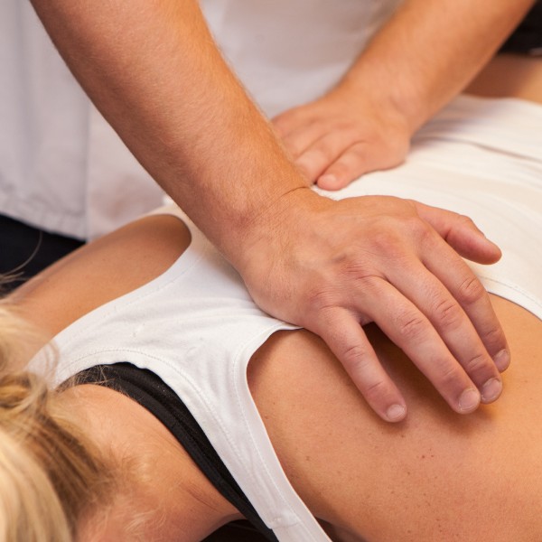 Image of osteopath treating a woman's shoulder